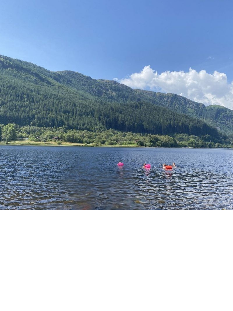 Open-water swimmers with VORLICH CAIRN tow-float swim buoys on a Scottish loch
