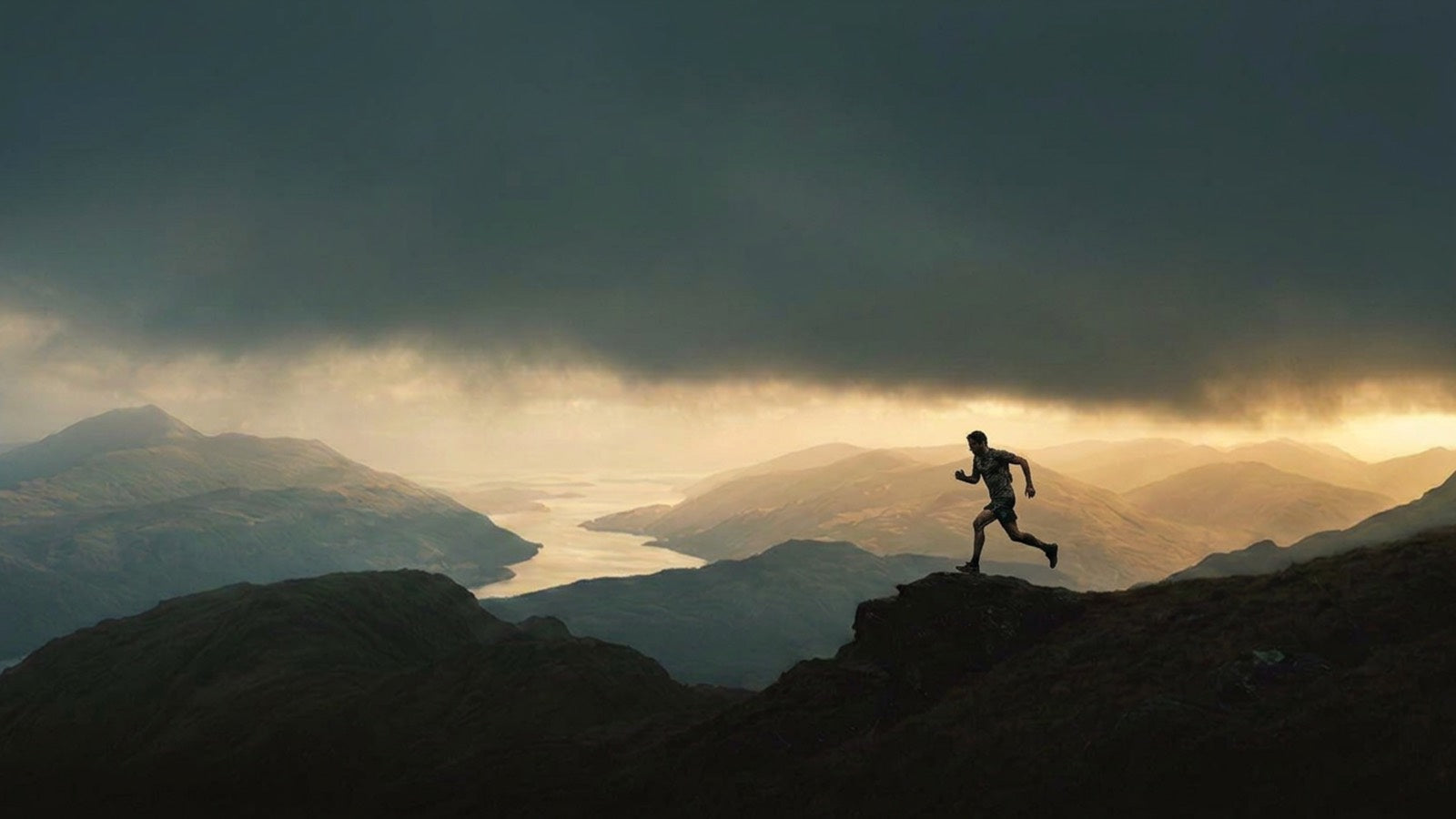 A runner crossing a ridge above the loch at Ben Vorlich