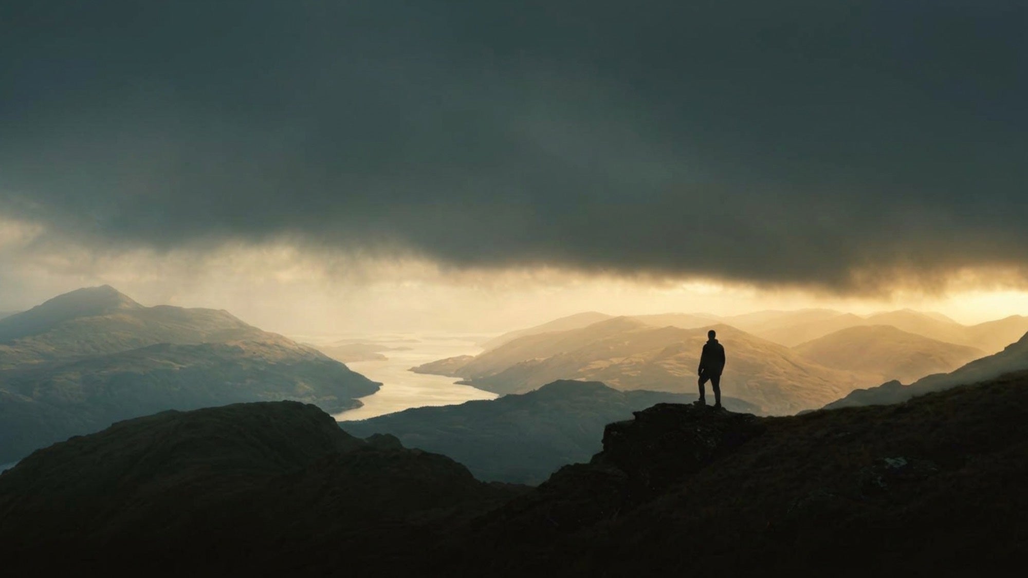 A figure on the Ben Vorlich summit looking down the loch under storm light